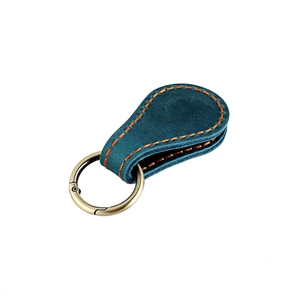Détail du porte-clés en cuir bleu avec couture orange et anneau en bronze