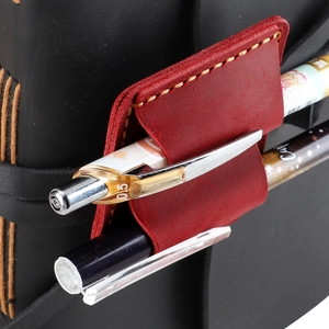Macro detail of red crazy horse leather pen holder with hand-stitched yellow thread