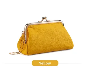 Macro detail of yellow litchi grain leather coin purse with golden metal clasp closure