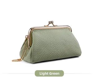 Detail of light green pebbled leather coin purse with golden clasp and chain strap