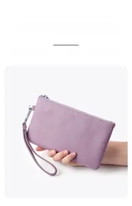 Close-up of purple top layer cowhide clutch with lychee texture and silver zipper detail