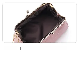 Close-up of pink lychee grain leather purse with gold clasp and soft brown lining