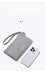 Detailed size comparison of a gray pebble grain leather wristlet wallet with a smartphone