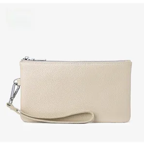 Detail of apricot genuine leather phone wallet with pebble grain texture and wrist strap