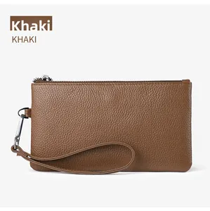 Detailed macro view of the khaki pebbled leather texture and silver zipper on the wallet