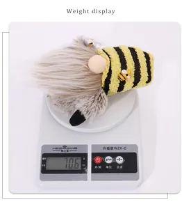 Detailed view of striped bee gnome doll weighing 70.6g on a digital scale