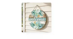 Detail of round wooden welcome sign with blue floral prints on rustic wood wall