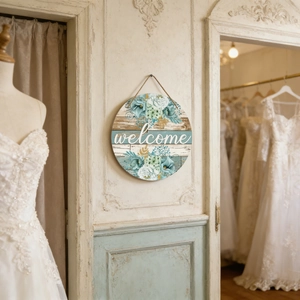 Detail of round wooden welcome sign with blue flowers and jute rope in boutique shop