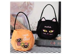 Detail of plush Halloween candy bags with spider and cat motifs on checkered surface