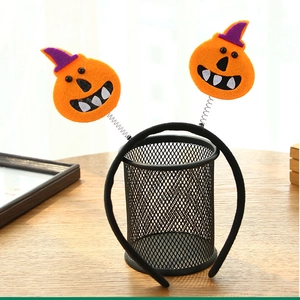 Detail of felt pumpkin springs on Halloween headband with purple witch hat accents