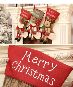 Dettaglio ravvicinato del ricamo Merry Christmas su calze natalizie in tessuto di qualità