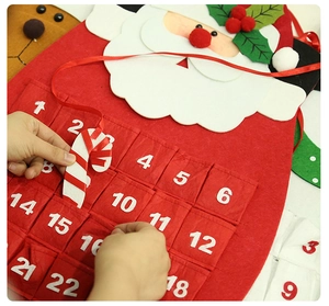 Detail of Santa felt Christmas advent calendar with 24 pockets and candy cane marker