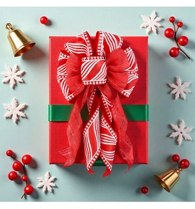 Detail of red and white striped Christmas bow on gift box with festive ornaments