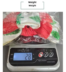 Detailed view of red Christmas bow ornament with tree pattern on a digital scale weighing 28g