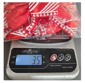 Detailed view of red Christmas bow ornament weighing 35g on a digital scale