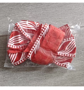 Close-up of red and white striped Christmas ribbon with wavy lace trim in packaging
