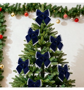 Close-up of velvet Christmas bows in navy blue with silver glitter on a festive tree