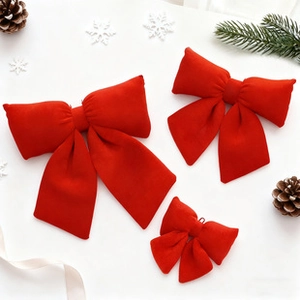 Detailed view of three red velvet bows in various sizes for festive holiday decoration
