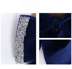 Detailed close-up of dark blue velvet Christmas bow with shimmering silver rhinestone edges