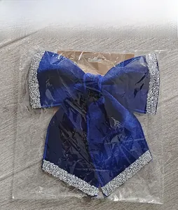 Detail view of a dark blue velvet Christmas bow with silver glitter in retail packaging