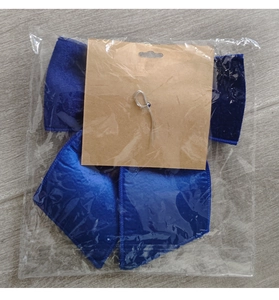Detailed view of blue fabric Christmas bow accessory in clear plastic bag packaging
