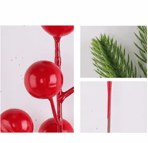 Detalle de bayas rojas artificiales y agujas de pino para decoración navideña