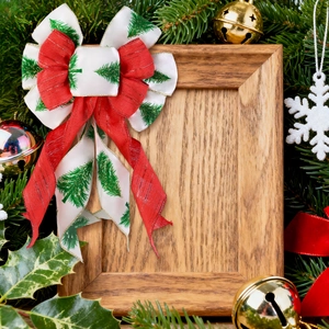 Rustic square wooden photo frame surrounded by festive Christmas bows and pine branches
