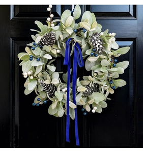 Detail of pine cones, blue berries, and velvet ribbon on the lamb ear door wreath