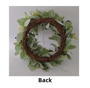 Rear view of decorative Christmas wreath with green leaves and berries on rattan base