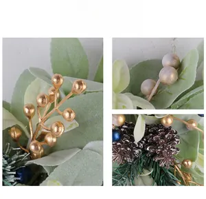 Close-up of frosted pine cones and metallic gold berries on a winter wreath decoration