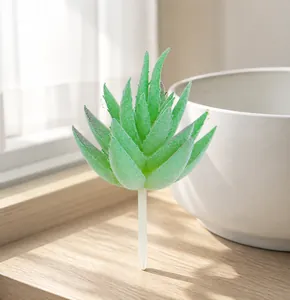 Detalle de suculenta artificial realista con hojas verdes escarchadas y tallo de plástico