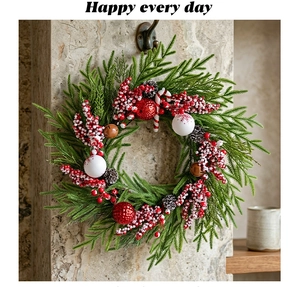 Nahaufnahme von Weihnachtskranz mit roten Beeren und Zapfen an einer Steinwand