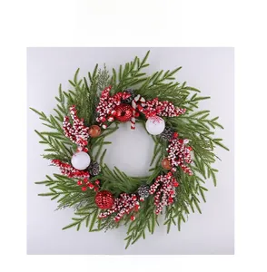 Detail eines Weihnachtskranzes mit Tannenzapfen, Beeren, Zuckerstangen und Kugeln