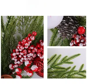 Details von roten Beeren und Tannennadeln mit Schneeeffekt und roter Weihnachtskugel