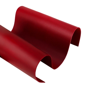Vista detallada de lámina de cuero rojo oscuro flexible con textura mate y ondulada