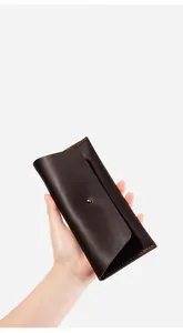 Détail du portefeuille mince en cuir marron foncé avec bouton pression et surpiqûres oranges