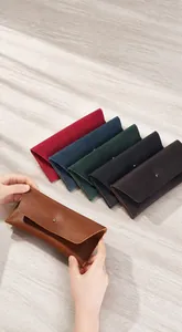 Détail d'un portefeuille enveloppe long en cuir avec fermoir métal et couture fine