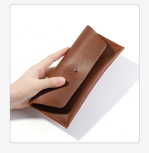 Detailansicht der braunen Leder-Clutch mit Metallniete und sauberer Naht im Retro-Design