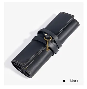 Detail of black genuine leather roll pencil case with retro key charm and stitching