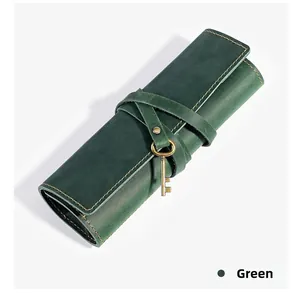 Close-up of green crazy horse leather roll pencil case with yellow stitching and key charm
