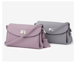 Detail of premium lychee grain leather crossbody bags with elegant gold twist-lock closures