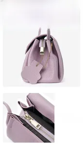Detail of purple lychee leather handbag featuring a bear charm and high-quality gold zipper