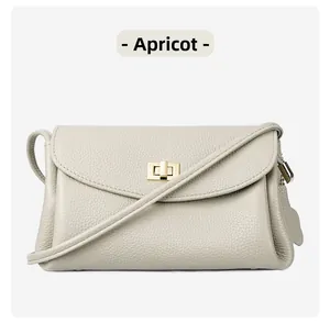 Close-up of apricot lychee pattern leather handbag with gold twist lock closure