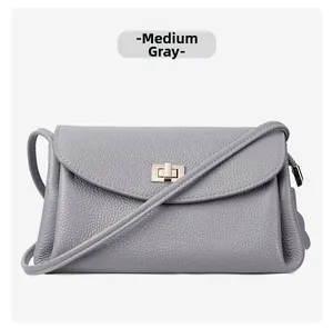Detail of medium grey pebble grain leather handbag featuring a golden metallic twist lock