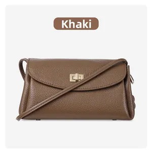 Detail of khaki pebbled leather texture and gold metal twist lock on mini crossbody bag