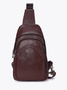 Detail of dark brown vegetable tanned leather chest bag with zipper pockets and metal hooks