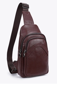 Detail of dark brown lychee grain leather crossbody bag with metal zippers and nylon strap