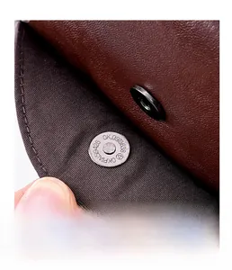 Close-up of magnetic snap fastener on premium lychee grain leather crossbody bag