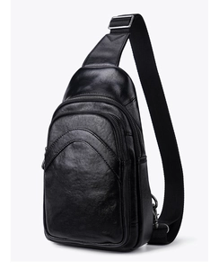 Detailed macro of black vegetable-tanned leather texture and dual zipper pockets on chest bag