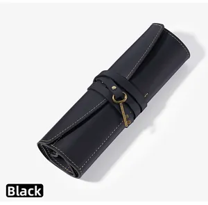 Dettaglio dell'astuccio in pelle nera arrotolato con chiave vintage e cuciture marroni